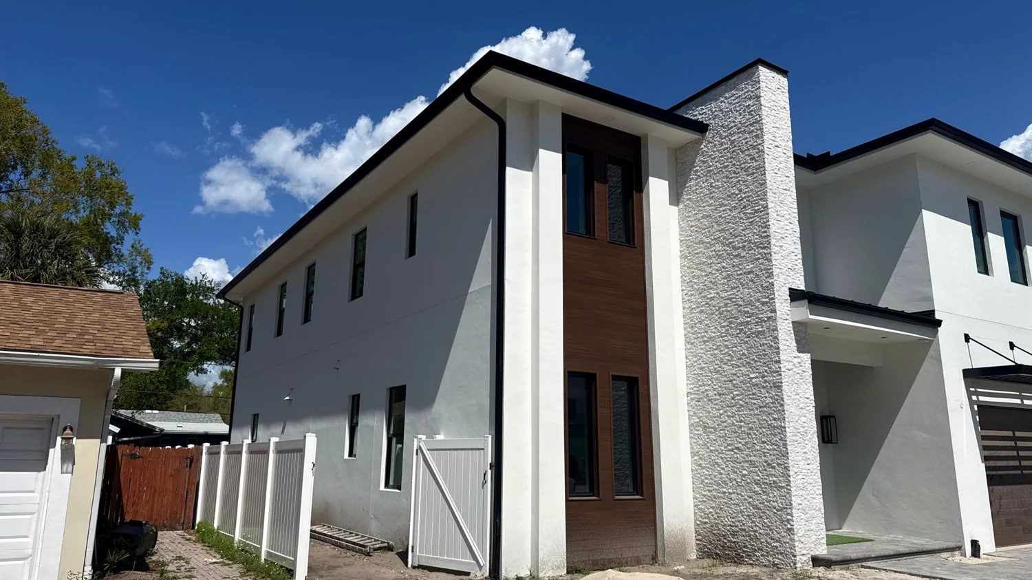Charcoal gutters contrasting light siding on a contemporary Orlando residence